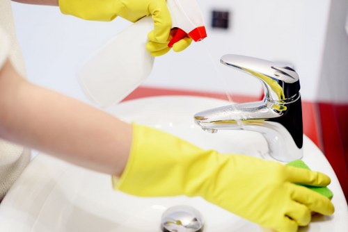 Staff member using cleaning products safely and checking labels
